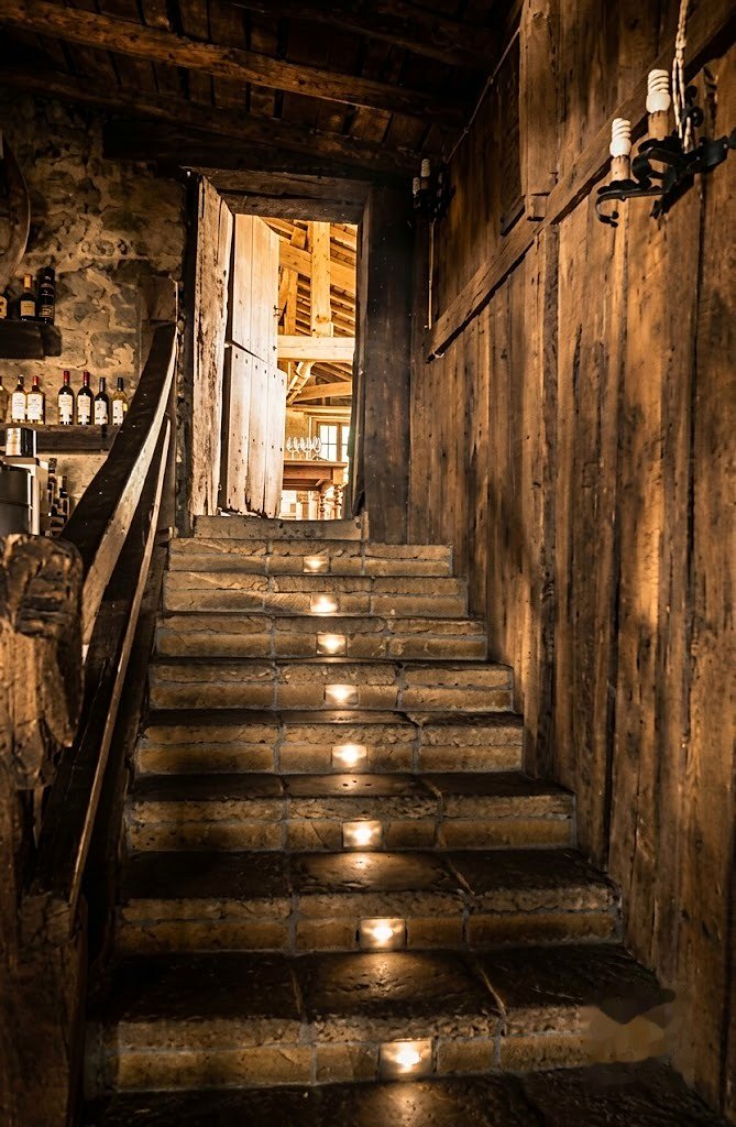 La escalera de madera del caserío junto a la pared de piedra y las vigas antiguas