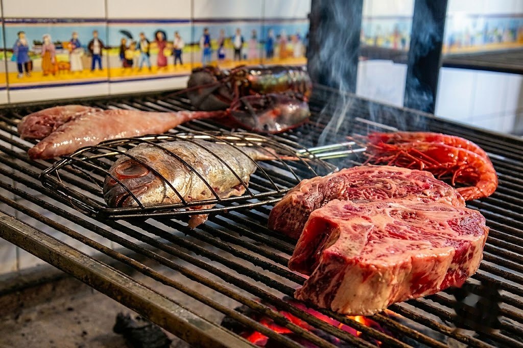 Txuletón sobre la parrilla con la brasa encendida debajo